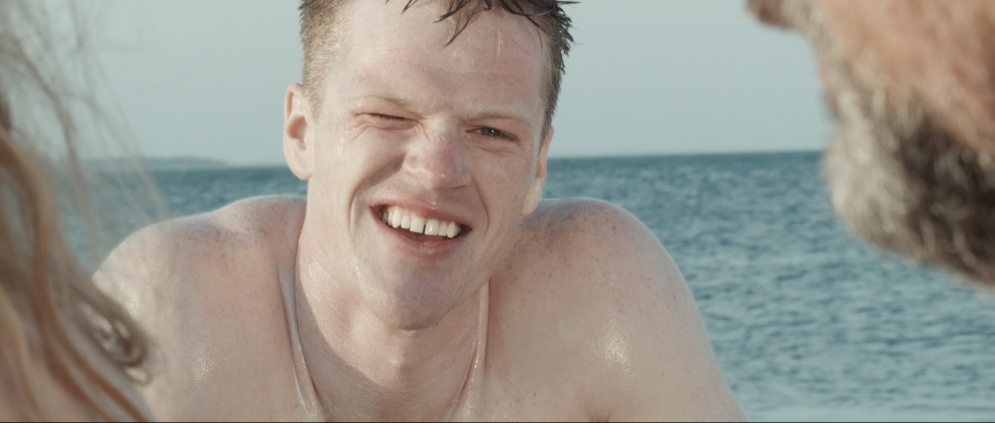 Cronos film still: a young man smiling at the beach