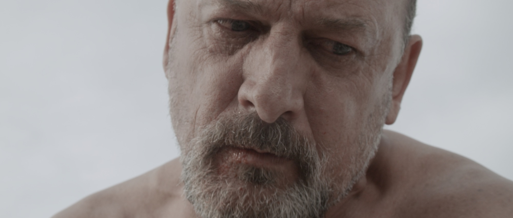 Cronos film still: an older man looking downward