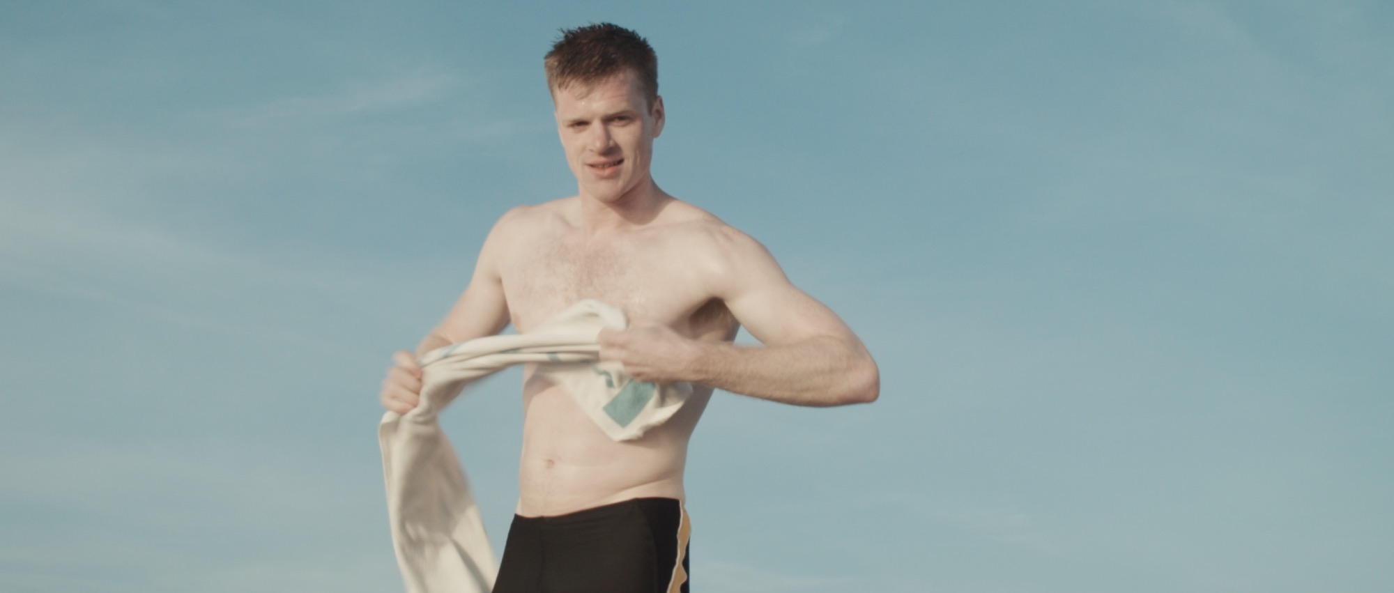 Cronos film still: a young man drying himself after swimming