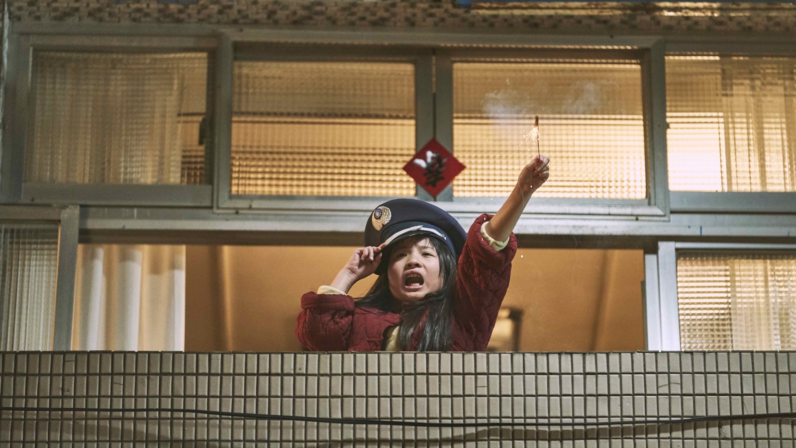 Yang Lan holding a sparkler on the balcony