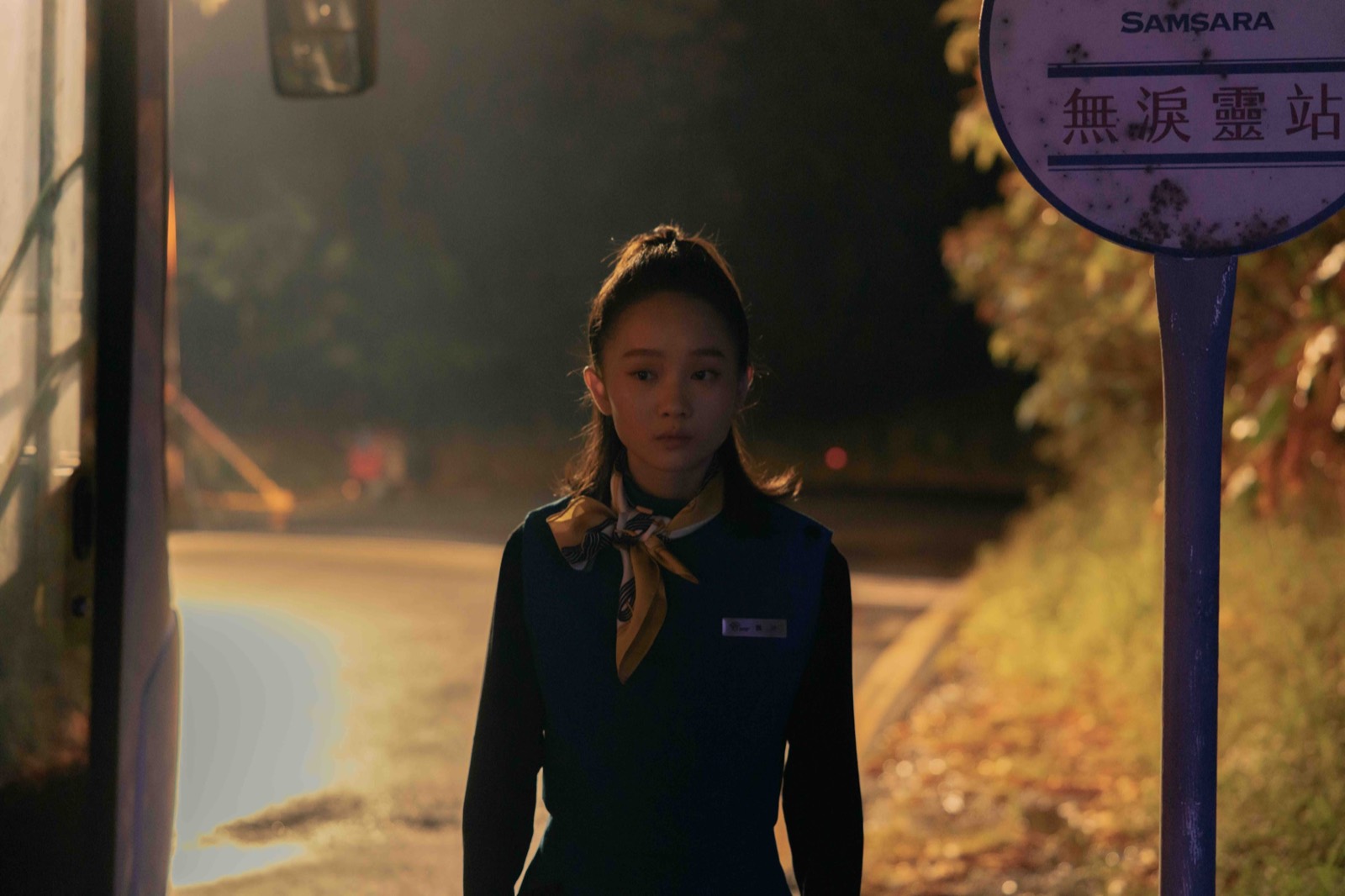 A young Hell airport attendant beside the No Tears station sign