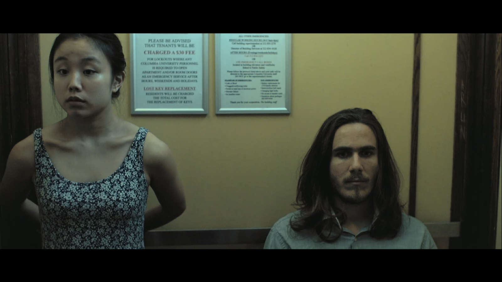 A woman and a man sitting in an elevator