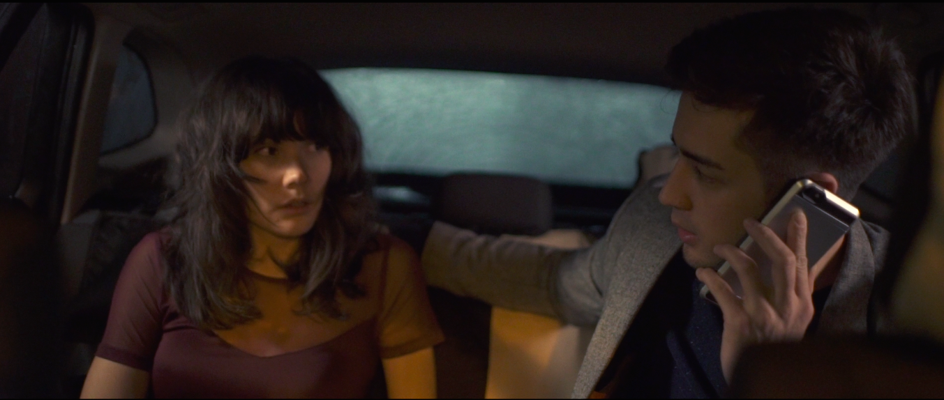 Sophia and Josh sitting together in the back seat of a car